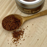 Close up of the contents on the tin of bbq seaweed rub - on a little wooden spoon showing the granules of the rub