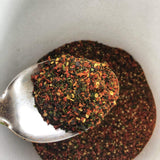 Image of crushed chillis with mixed seaweed flakes before the salt has been added