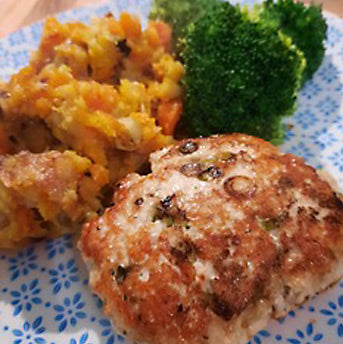 Burger made from turkey mince with spring onions and seaweed flakes cooked until golden brown, shown on a blue and white patterned plate with green steamed broccoli and a mash made from carrots and butternut squash