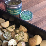 potatoes in a baking tray sprinkled with herby seaweed seasoning